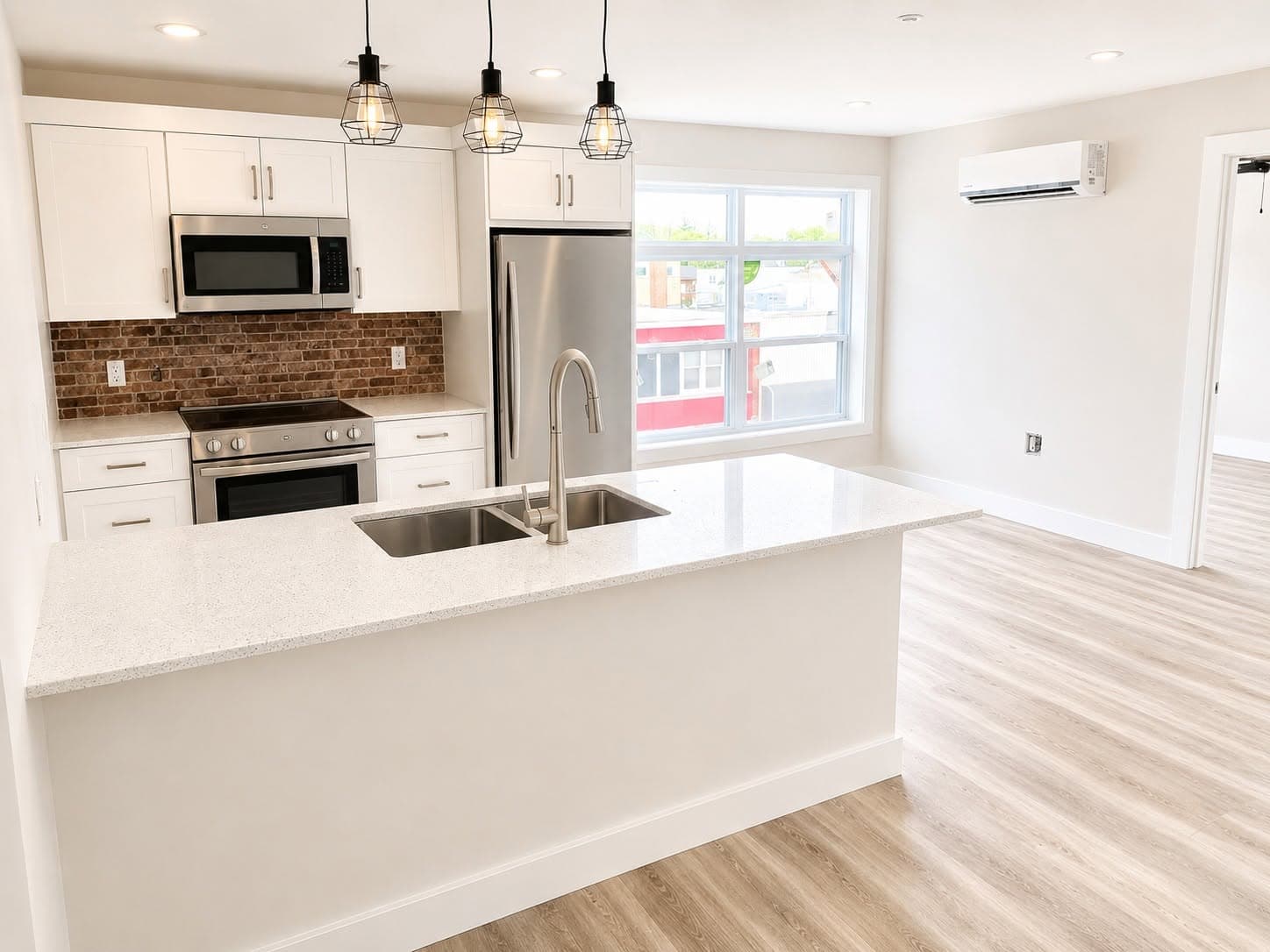 278 Water Street — white shaker kitchen with quartz island, pendant lighting, and brick backsplash